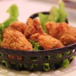 deep fried chicken drumpsticks with vegetables in black basket
