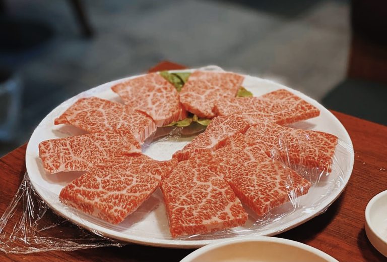 highly marbled wagyu beef slices on white plate