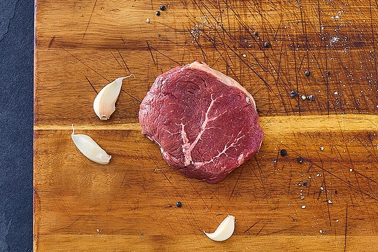 Grass fed Top Sirloin Steak on wooden chopping board leanest steak cuts