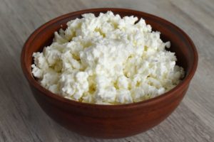 cottage cheese in a brown wooden bowl