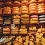 various types of cheese wheels on shelf