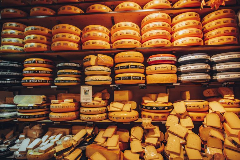 various types of cheese wheels on shelf