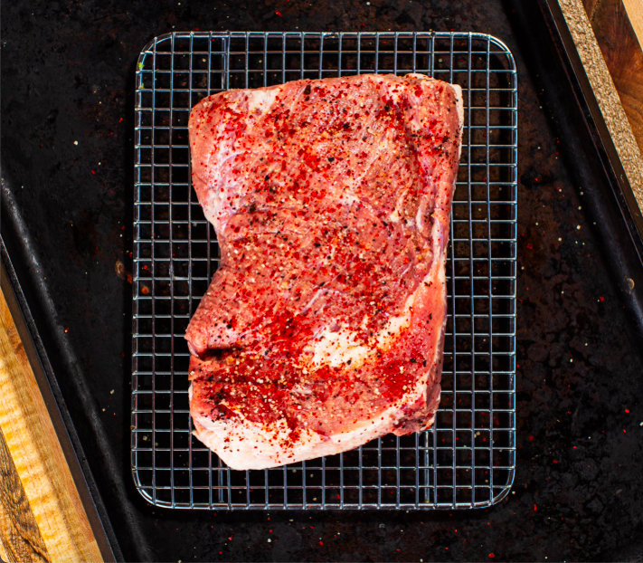 Marinated Pork Brisket on a stainless steel grate