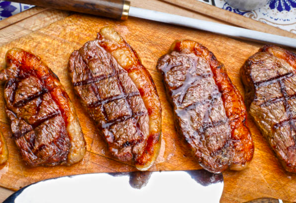 Grilled picanha steaks on wooden board