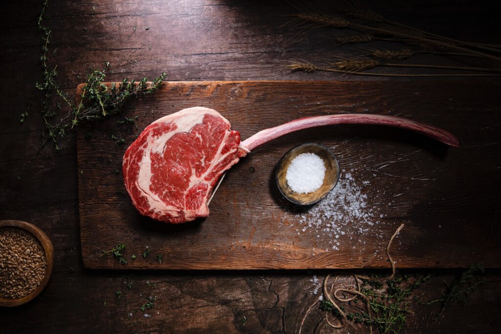 Tomahawk Ribeye Steak with large rib bone on a wooden board